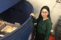 Researcher Sophie Wang stands by a centrifuge