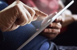 a senior citizen working on a computer tablet