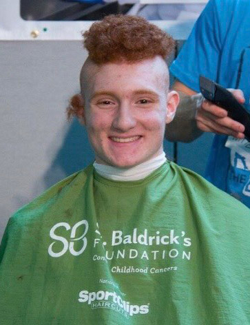 Nedal Eid in the middle of having his hair shaved at Shave It Off event