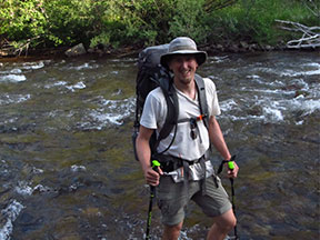 Researcher Nicholas Sutfin standing in shallow St. Vrain Creek, a 32-mile-long tributary of the South Platte River in north central Colorado.